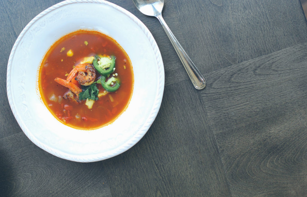 Spicy tortilla soup with shrimp and avocado